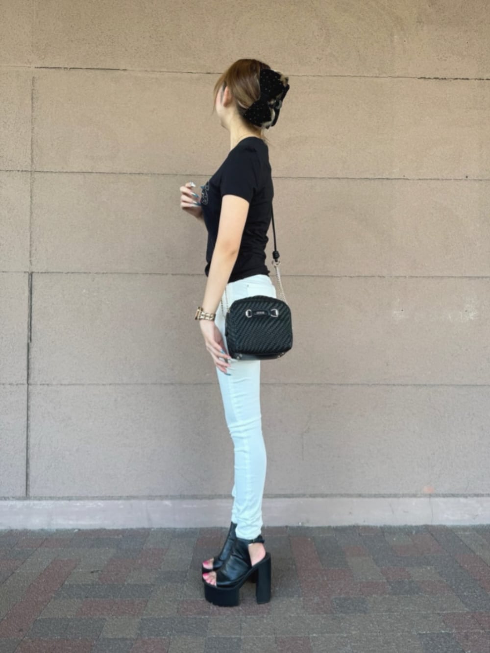 ホワイト系のデニムパンツ、ブラック系のTシャツ/カットソー、ブラック系のショルダーバッグを着用したレディースの冬コーディネートの3枚目の写真