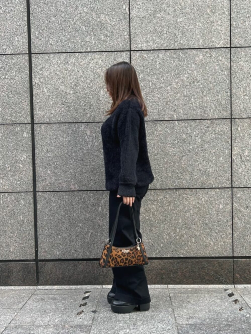 ブラック系のデニムパンツ、ブラック系のニット/セーター、その他のハンドバッグを着用したレディースの冬コーディネートの3枚目の写真