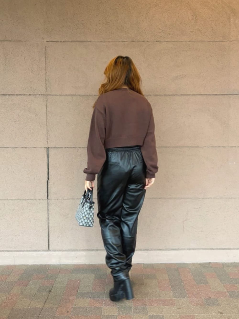 ブラック系のその他パンツ、ブラック系のショルダーバッグ、ブラウン系のニット/セーターを着用したレディースの冬コーディネートの3枚目の写真