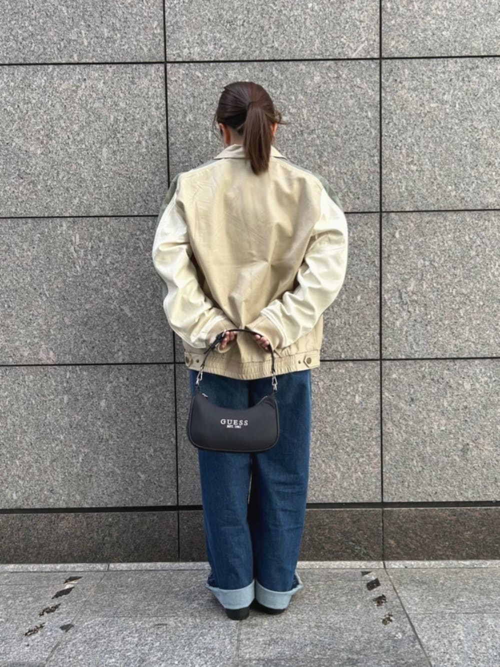 ベージュ系のその他アウター、ブルー系のデニムパンツ、ブラック系のショルダーバッグを着用したレディースの秋コーディネートの2枚目の写真