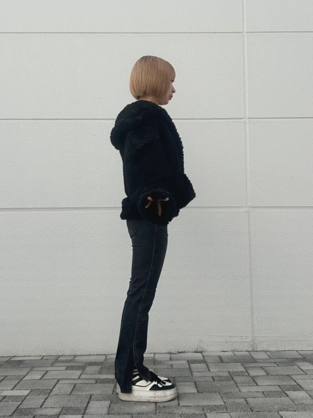 ベージュ系のニット/セーター、ブラック系のその他アウターを着用したレディースの秋コーディネートの3枚目の写真