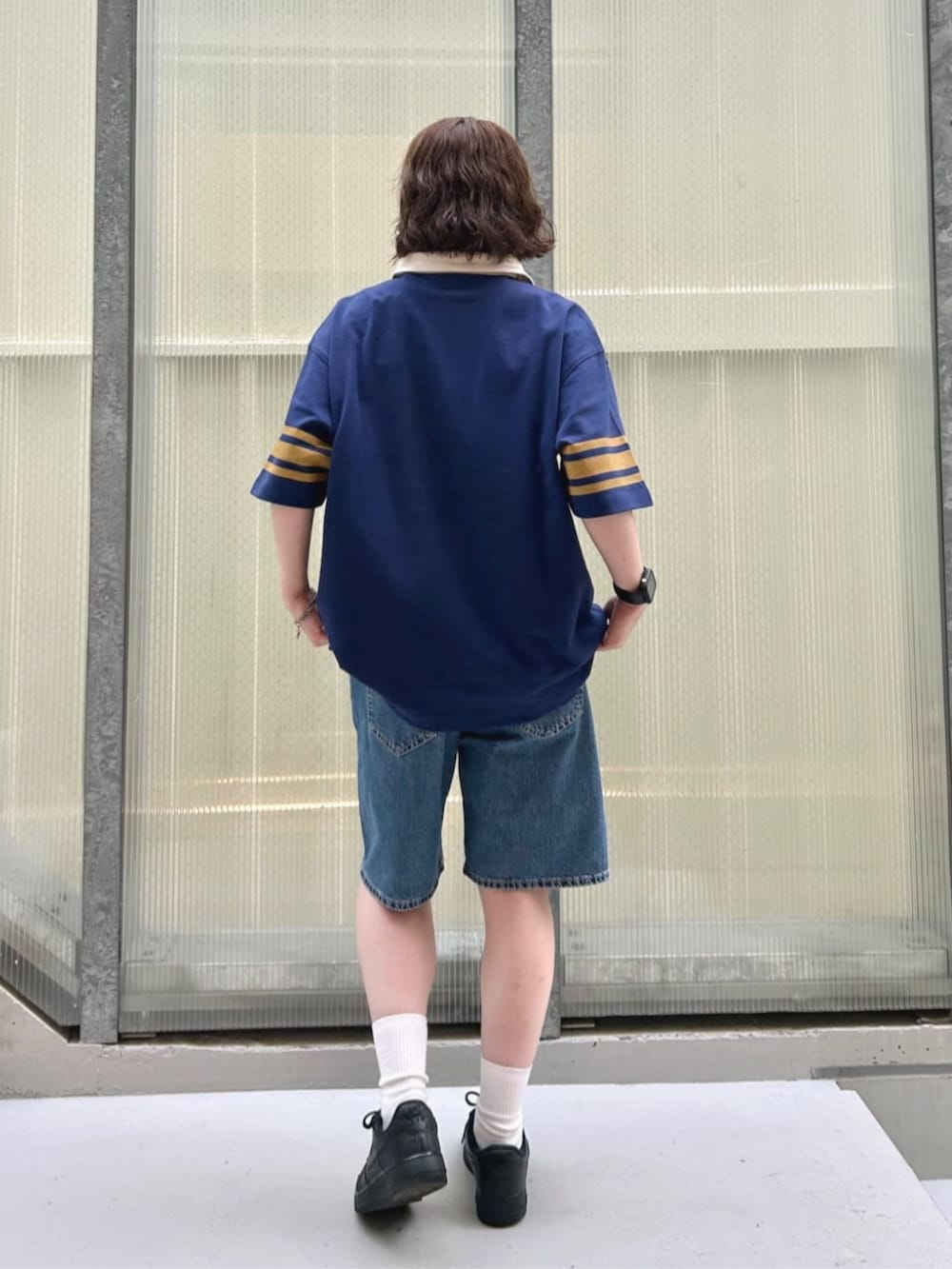 ブルー系のポロシャツ、ブルー系のデニムパンツを着用したレディースの夏コーディネートの2枚目の写真