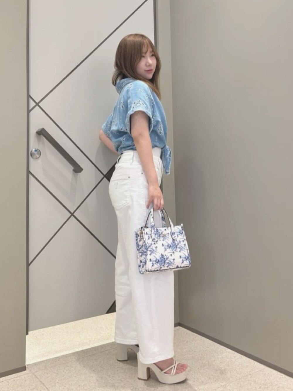 ホワイト系のショルダーバッグ、ブルー系のシャツ/ブラウス、ホワイト系のTシャツ/カットソーを着用したレディースの夏コーディネートの3枚目の写真