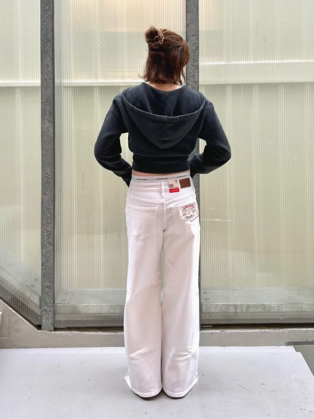 ホワイト系のデニムパンツ、ブラック系のパーカー、グレー系のショーツを着用したレディースの秋コーディネートの2枚目の写真