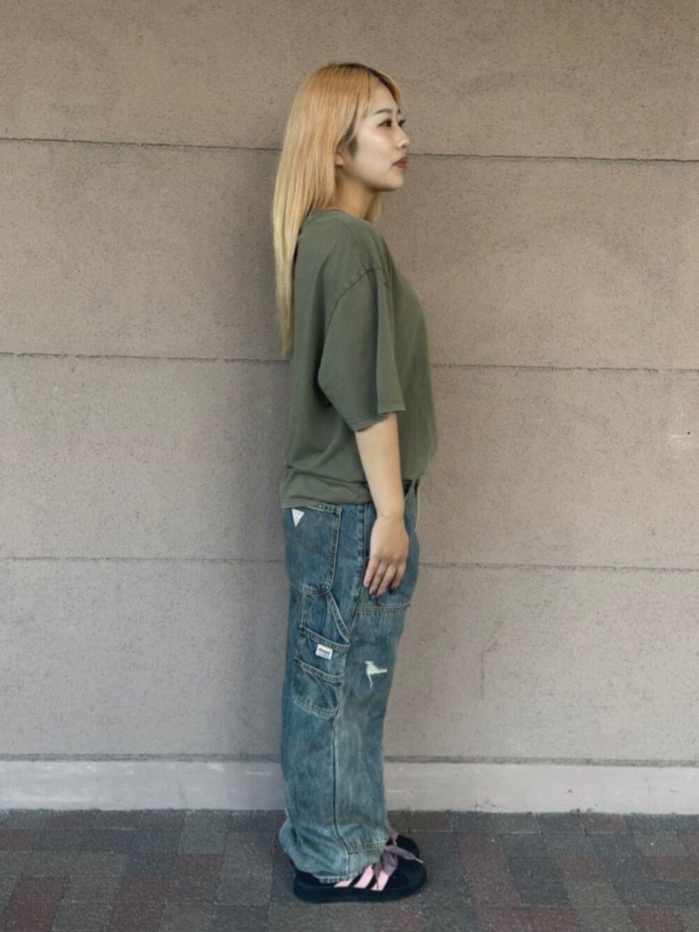 グリーン系のTシャツ/カットソー、ブルー系のデニムパンツを着用したレディースの秋コーディネートの3枚目の写真