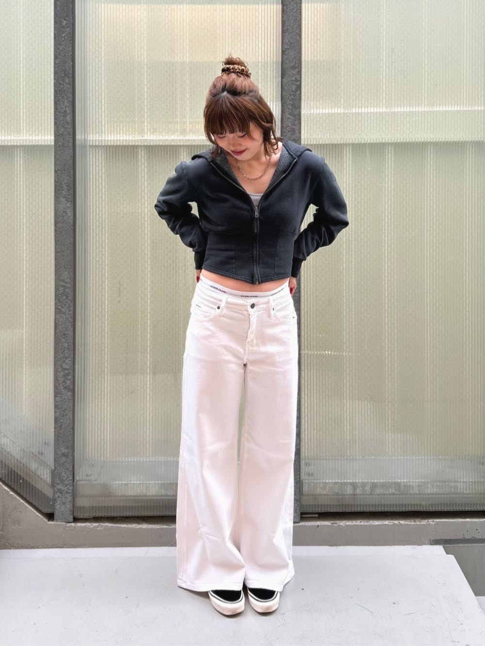 ホワイト系のデニムパンツ、ブラック系のパーカー、グレー系のショーツを着用したレディースの秋コーディネートの4枚目の写真