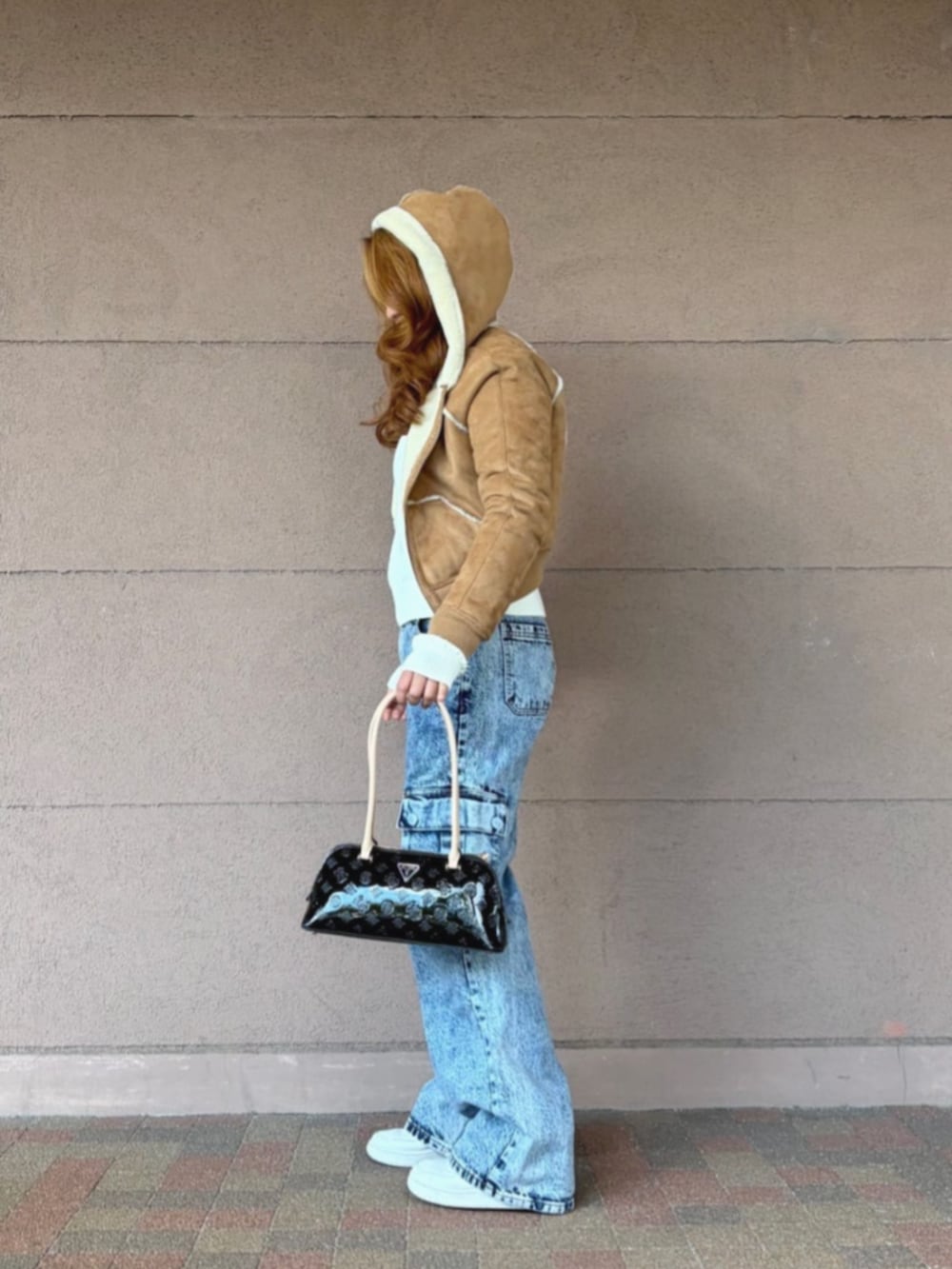 ベージュ系のパーカー、ブラック系のショルダーバッグ、ホワイト系のニット/セーターを着用したレディースの冬コーディネートの3枚目の写真