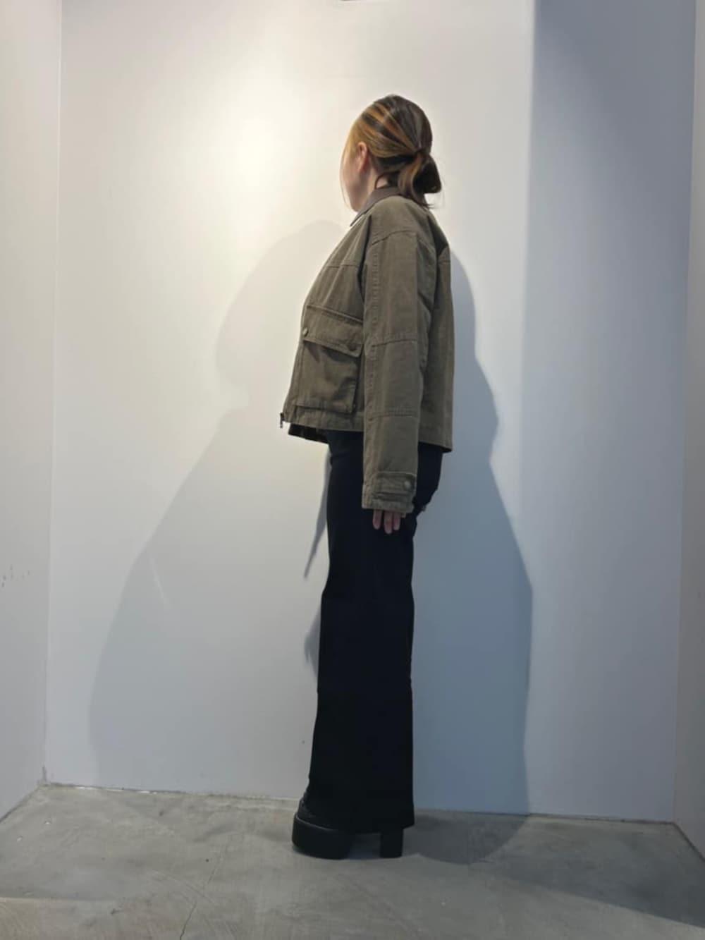 ブラック系のデニムパンツ、ブラック系のTシャツ/カットソー、グリーン系のミリタリージャケットを着用したレディースの春コーディネートの4枚目の写真