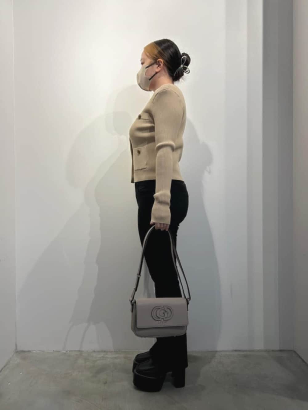 ベージュ系のカーディガン/ボレロ、ブラック系のデニムパンツ、ベージュ系のショルダーバッグを着用したレディースの冬コーディネートの3枚目の写真