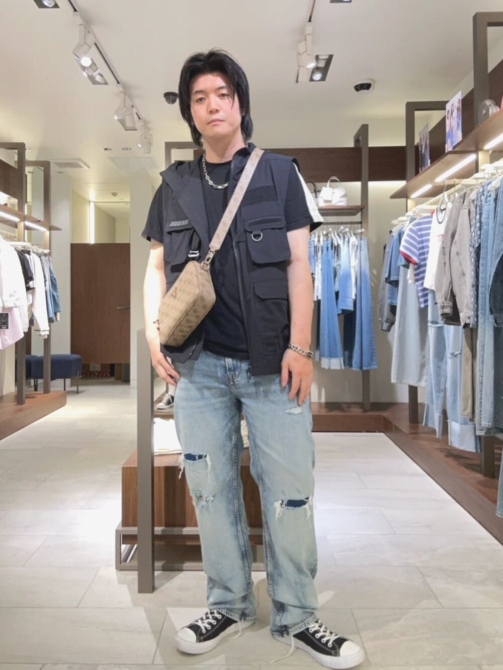 ベージュ系のショルダーバッグ、ブルー系のデニムパンツを着用したメンズの夏コーディネートの4枚目の写真