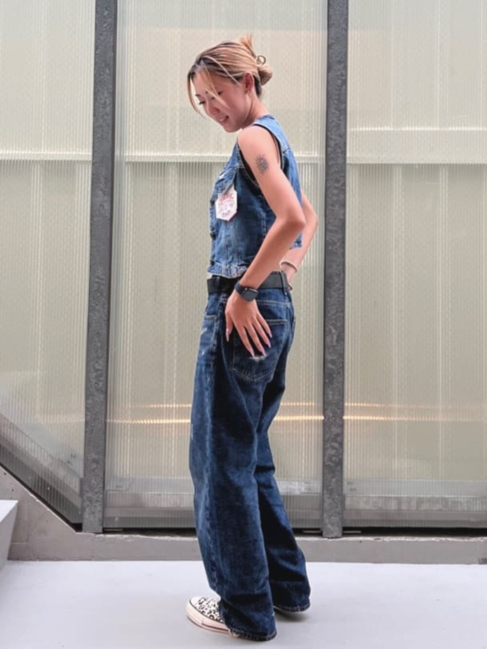 ブルー系のデニムパンツ、ブルー系のベストを着用したレディースの夏コーディネートの5枚目の写真
