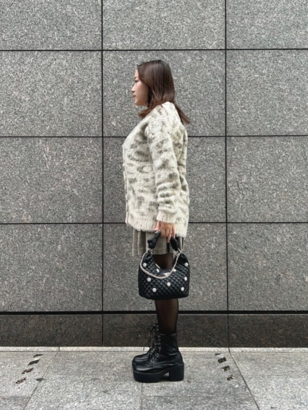 ブラック系のショルダーバッグ、その他のカーディガン/ボレロ、ベージュ系のスカートを着用したレディースの秋コーディネートの3枚目の写真