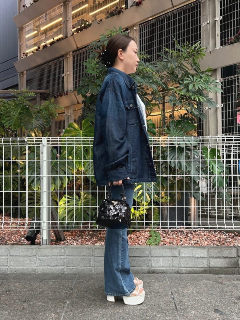 ブルー系のデニムパンツ、ブラック系のショルダーバッグ、ブルー系のシャツ/ブラウスを着用したレディースの秋コーディネートの3枚目の写真