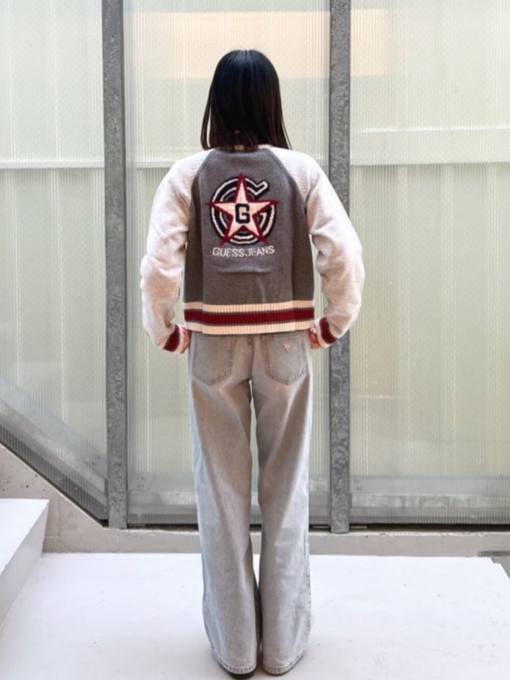 ブルー系のデニムパンツ、グレー系のカーディガン/ボレロを着用したレディースの冬コーディネートの2枚目の写真