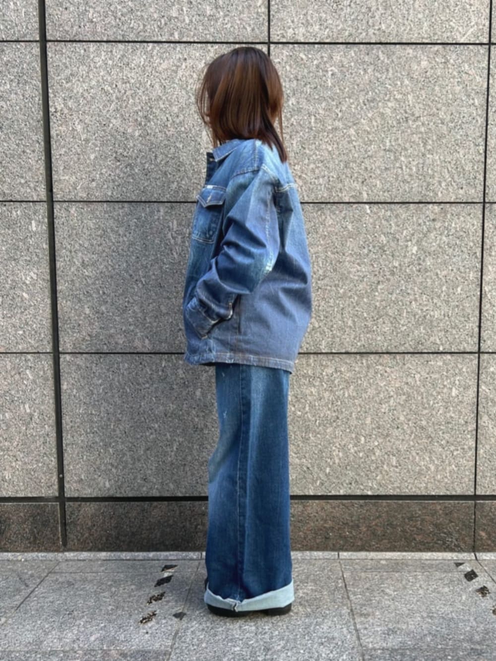 ブルー系のデニムパンツ、ブルー系のデニムジャケット、ブラック系のニット/セーターを着用したレディースの秋コーディネートの3枚目の写真