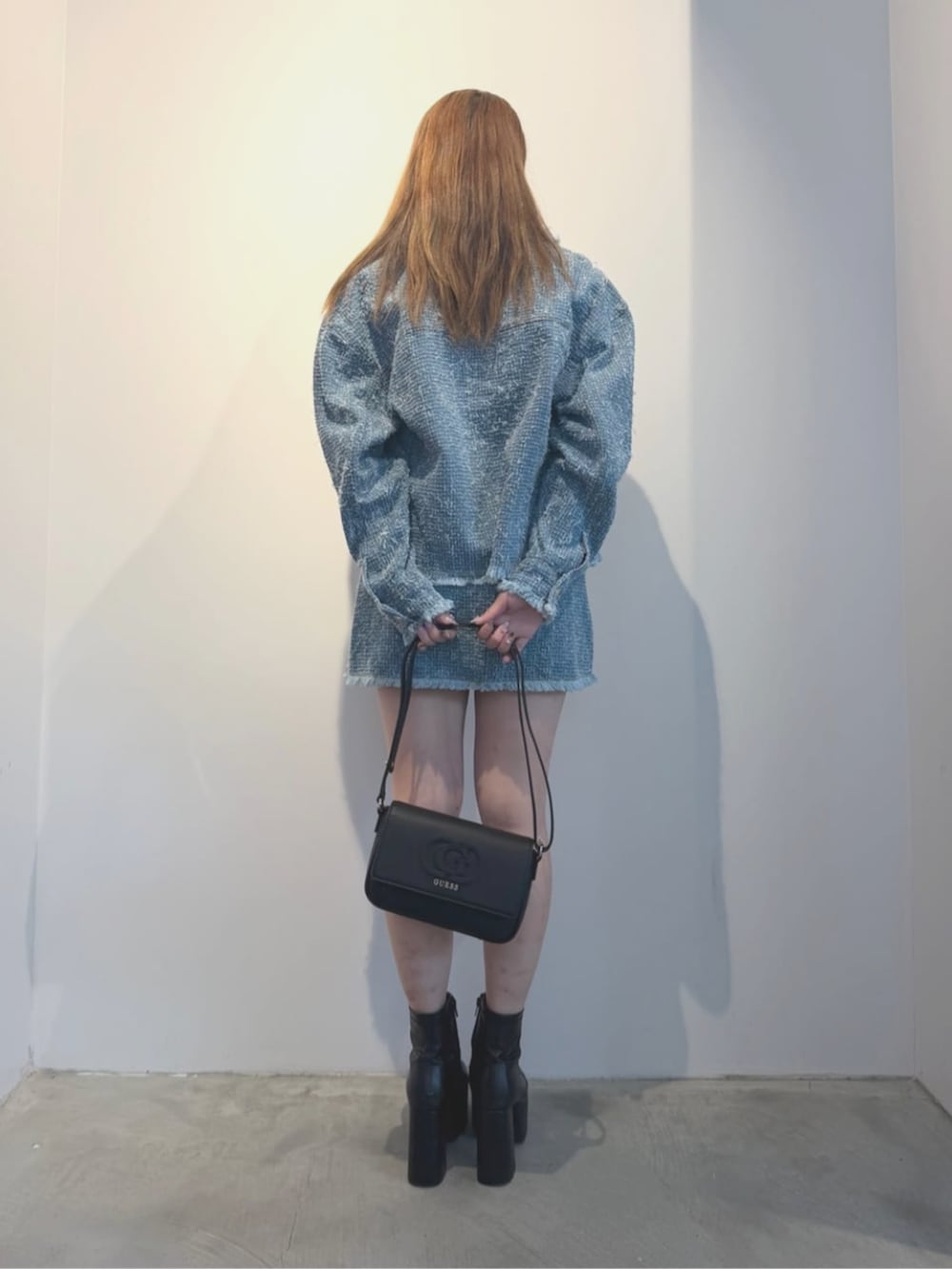 ブラック系のショルダーバッグ、ブルー系のTシャツ/カットソー、ブルー系のノーカラージャケットを着用したレディースの春コーディネートの2枚目の写真