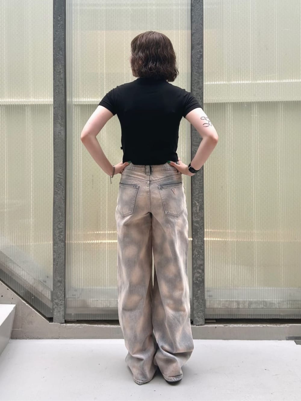 ブラック系のTシャツ/カットソー、ブルー系のデニムパンツを着用したレディースの夏コーディネートの2枚目の写真