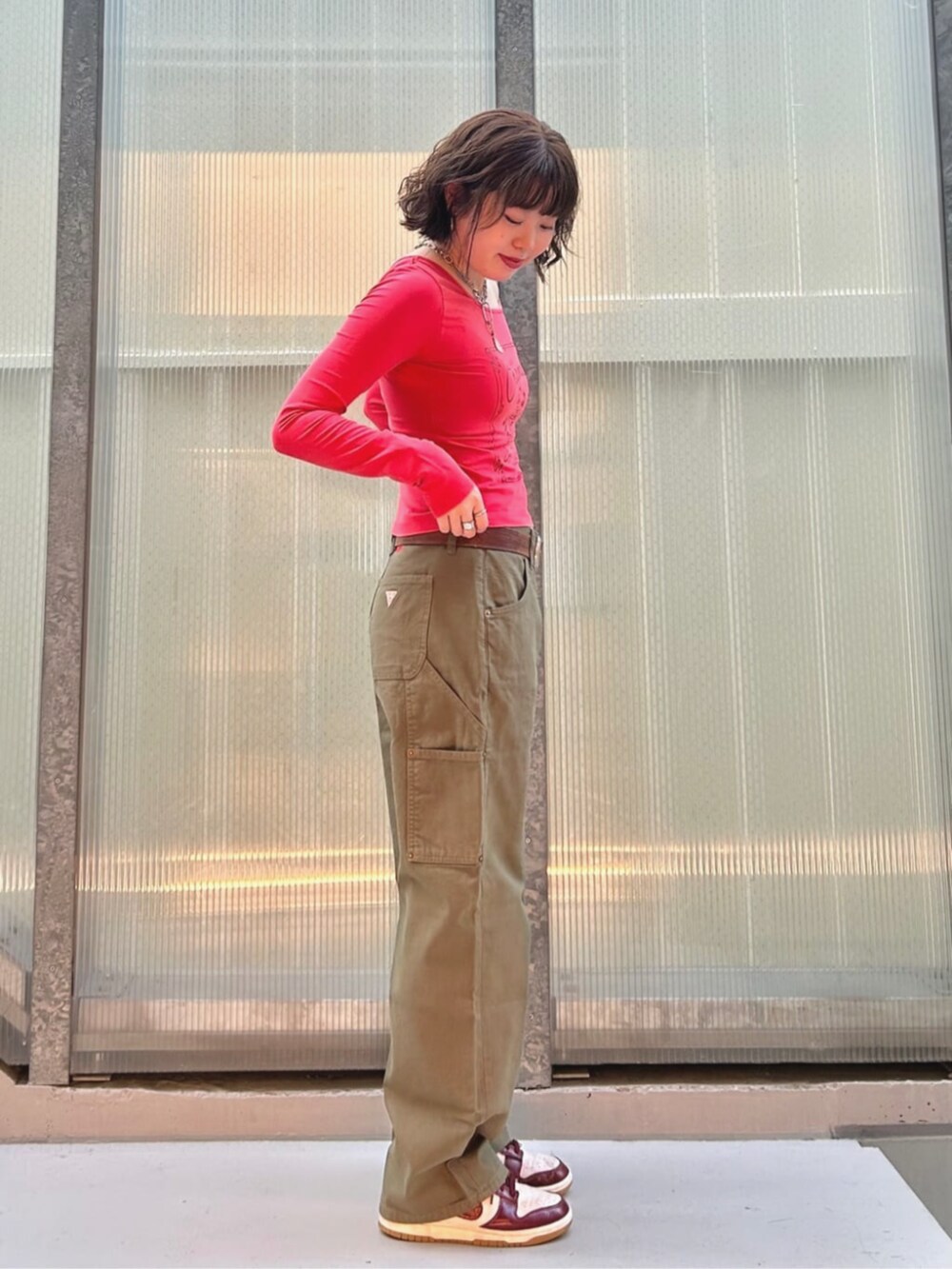 オレンジ系のTシャツ/カットソー、グリーン系のカーゴパンツを着用したレディースの夏コーディネートの3枚目の写真