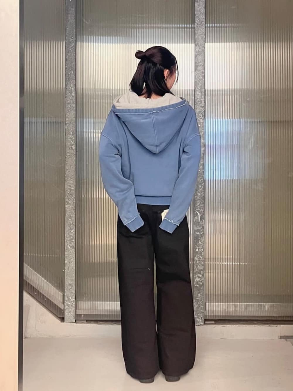 グレー系のパーカー、ブラック系のデニムパンツ、ブルー系のパーカーを着用したレディースの秋コーディネートの2枚目の写真