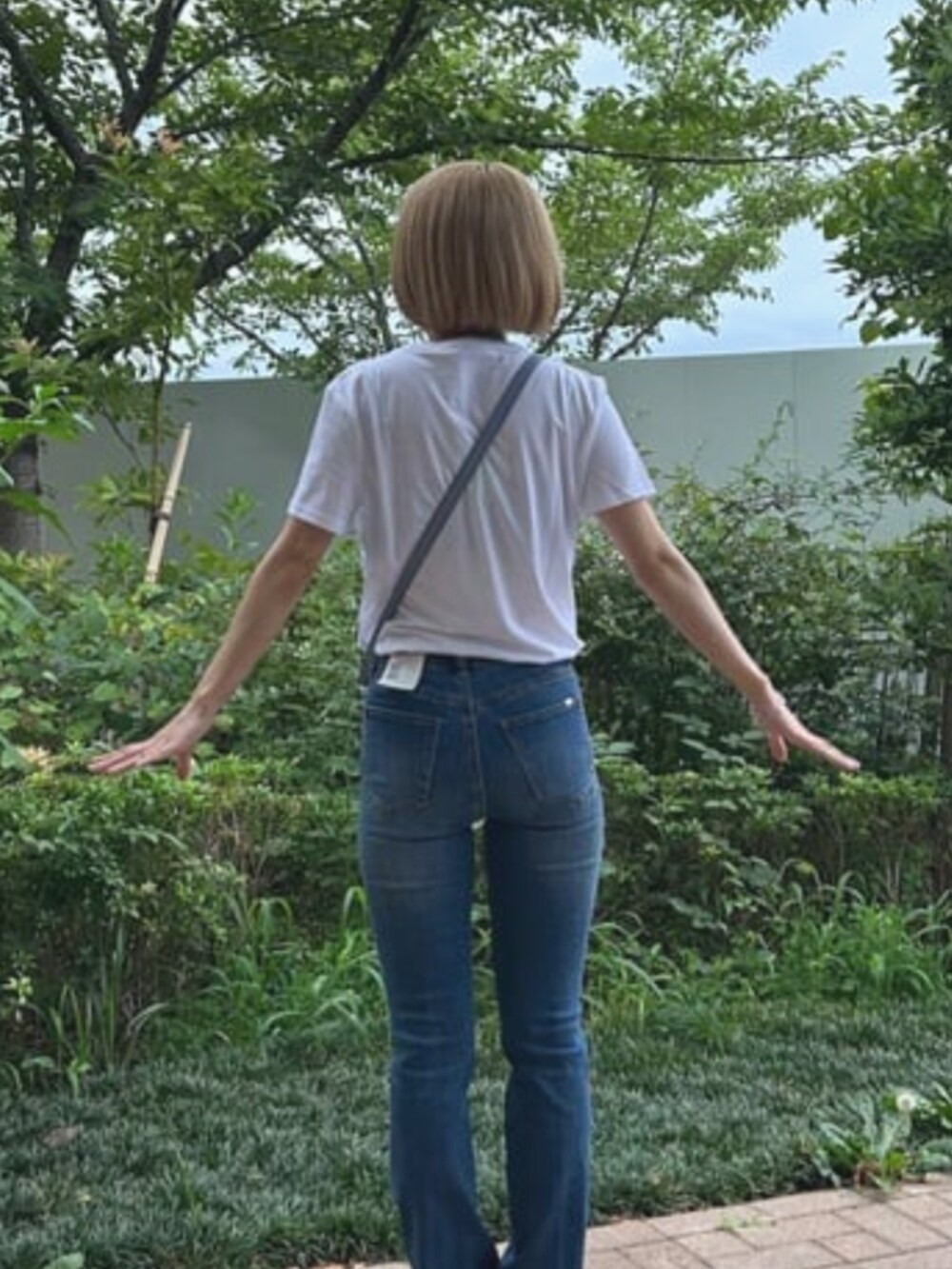 ブルー系のショルダーバッグを着用したレディースの夏コーディネートの2枚目の写真