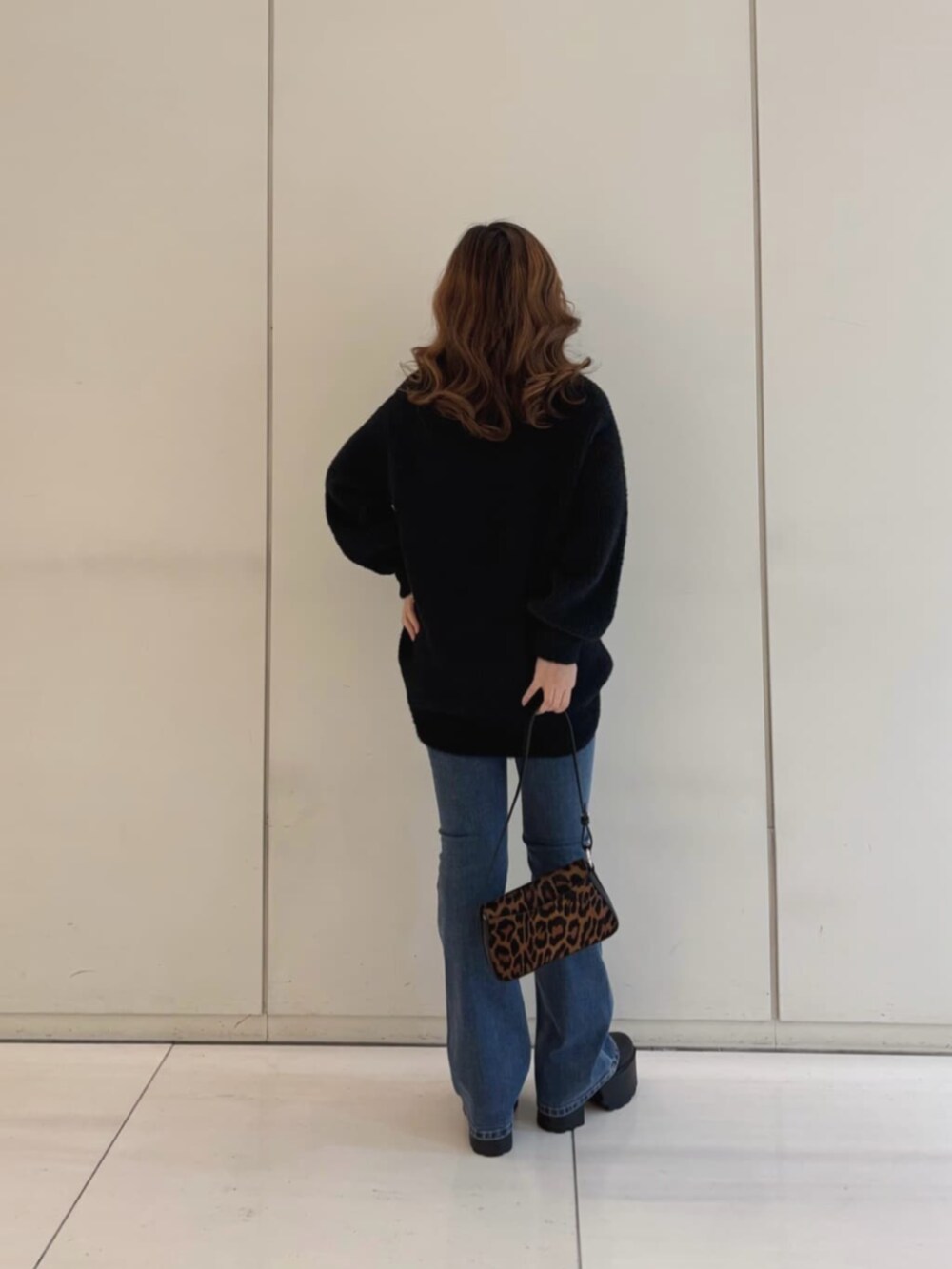 ブルー系のデニムパンツ、ブラック系のニット/セーター、その他のハンドバッグを着用したレディースの冬コーディネートの2枚目の写真