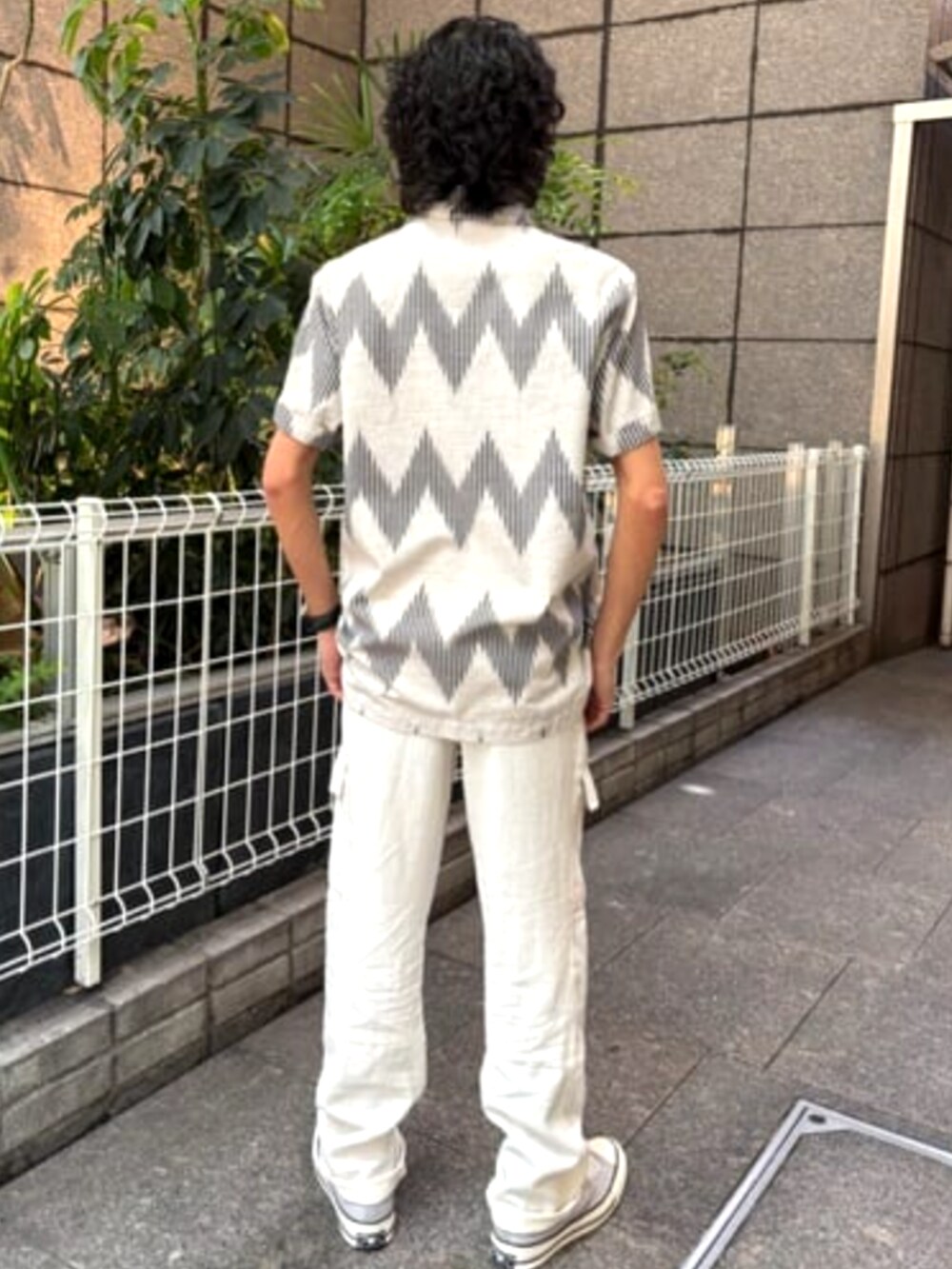 ベージュ系のTシャツ/カットソー、ホワイト系のカーゴパンツを着用したメンズの夏コーディネートの2枚目の写真