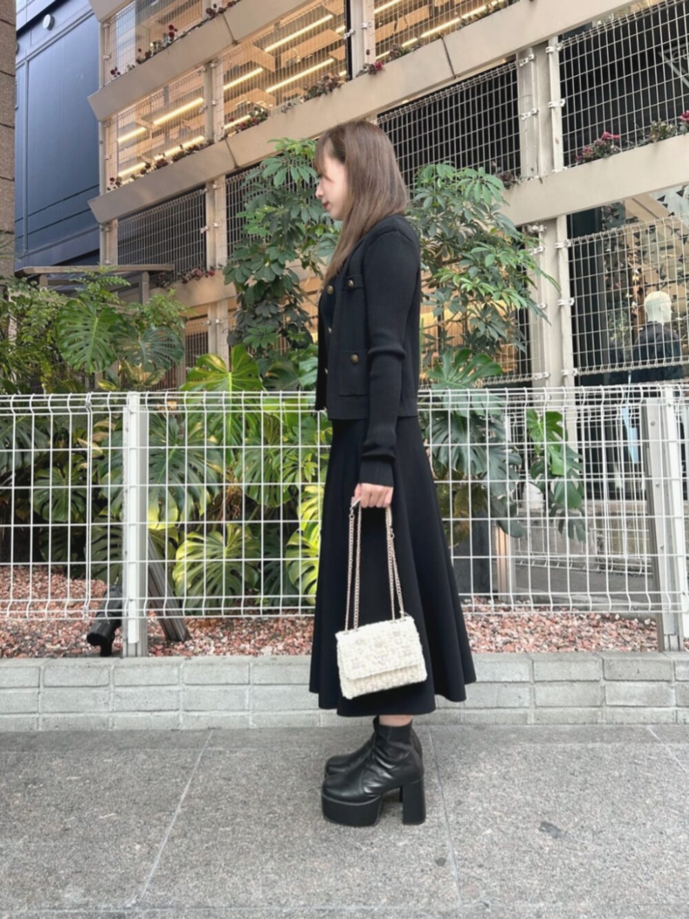 ブラック系のワンピース、ブラック系のカーディガン/ボレロ、ホワイト系のショルダーバッグを着用したレディースの秋コーディネートの3枚目の写真