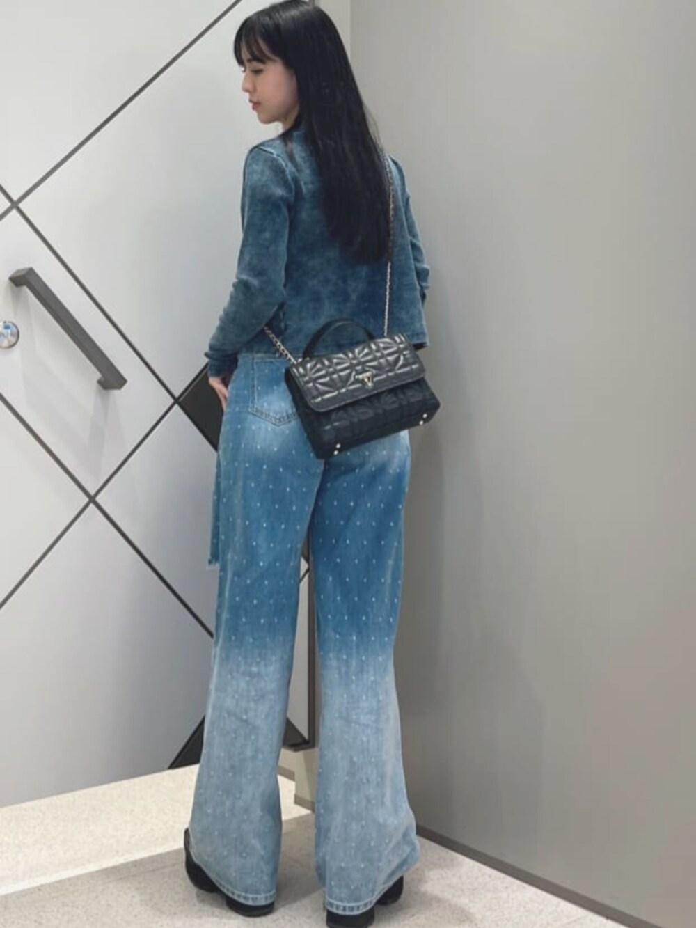 ブルー系のデニムパンツ、ブルー系のカーディガン/ボレロ、ホワイト系のタンクトップを着用したレディースの夏コーディネートの2枚目の写真