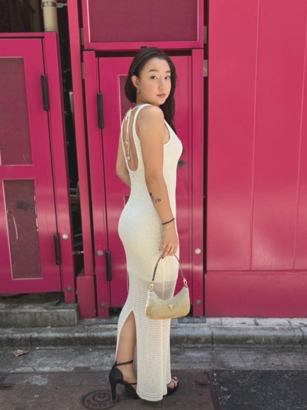 ゴールド系のハンドバッグ、その他のワンピース、ゴールド系のブレスレットを着用したレディースの夏コーディネートの3枚目の写真