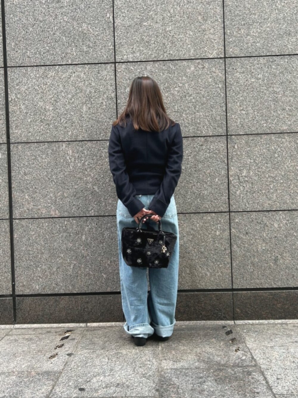 ブルー系のデニムパンツ、ブルー系のピーコート、ブラック系のショルダーバッグを着用したレディースの冬コーディネートの2枚目の写真