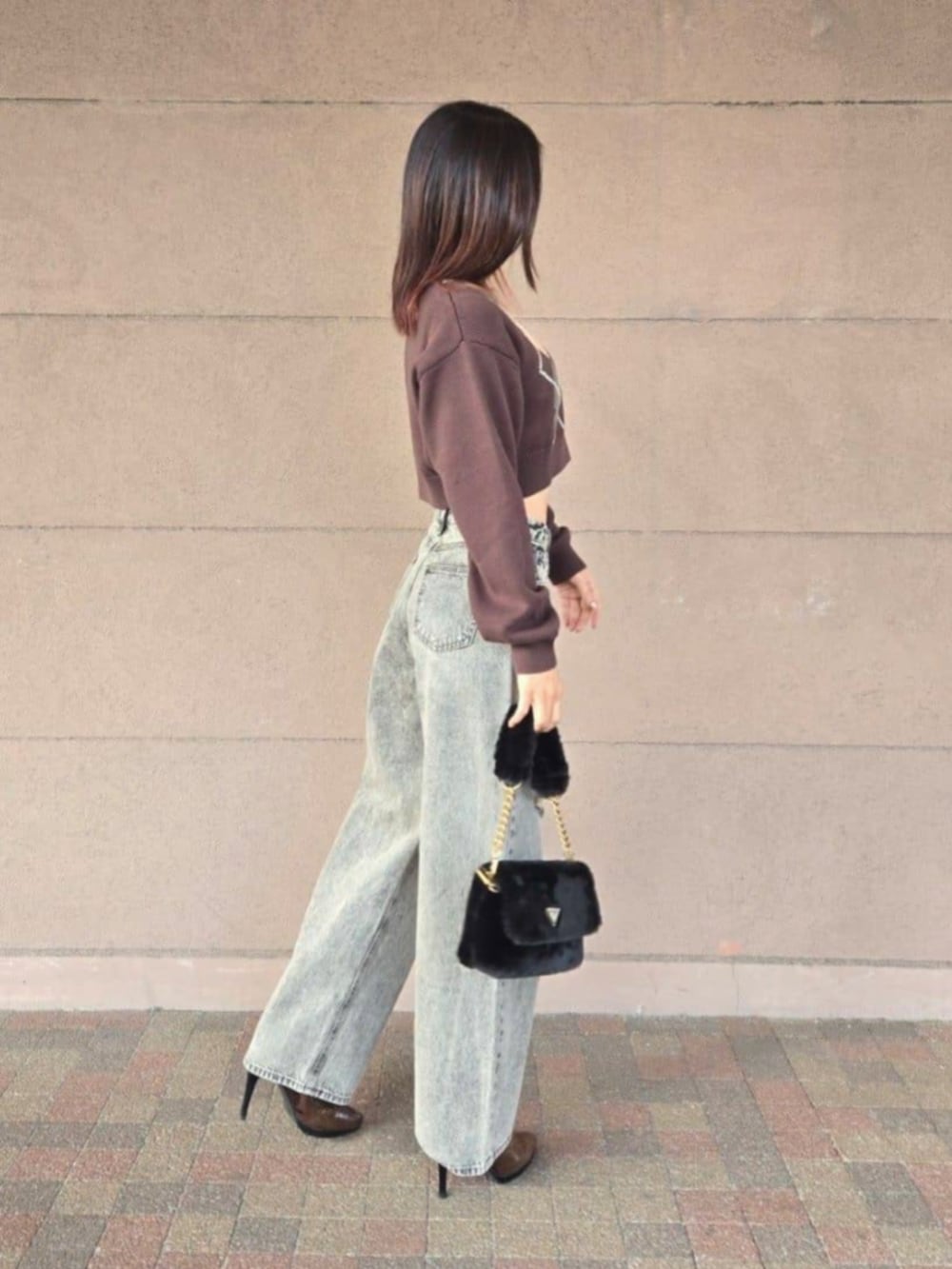 ブラック系のショルダーバッグ、グレー系のデニムパンツ、ブラウン系のニット/セーターを着用したレディースの冬コーディネートの3枚目の写真