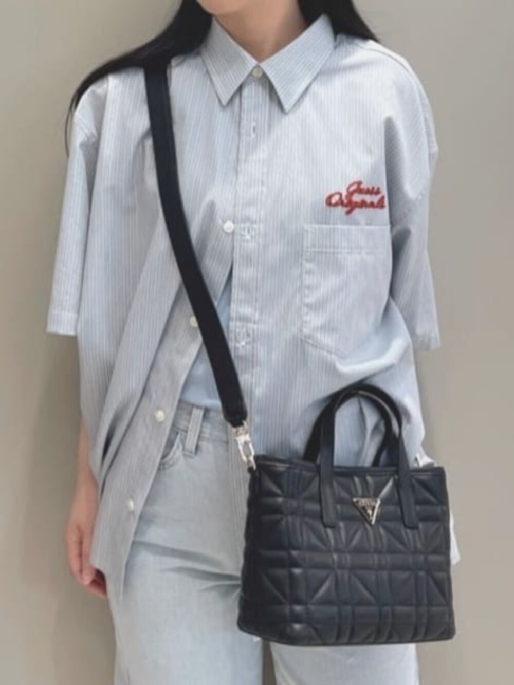 ブルー系のタンクトップ、ブルー系のデニムパンツ、ブラック系のショルダーバッグを着用したレディースの夏コーディネートの5枚目の写真