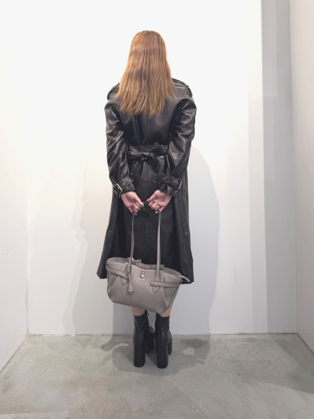 ブラウン系のトレンチコート、ベージュ系のトートバッグ、ブラウン系のワンピースを着用したレディースの春コーディネートの3枚目の写真