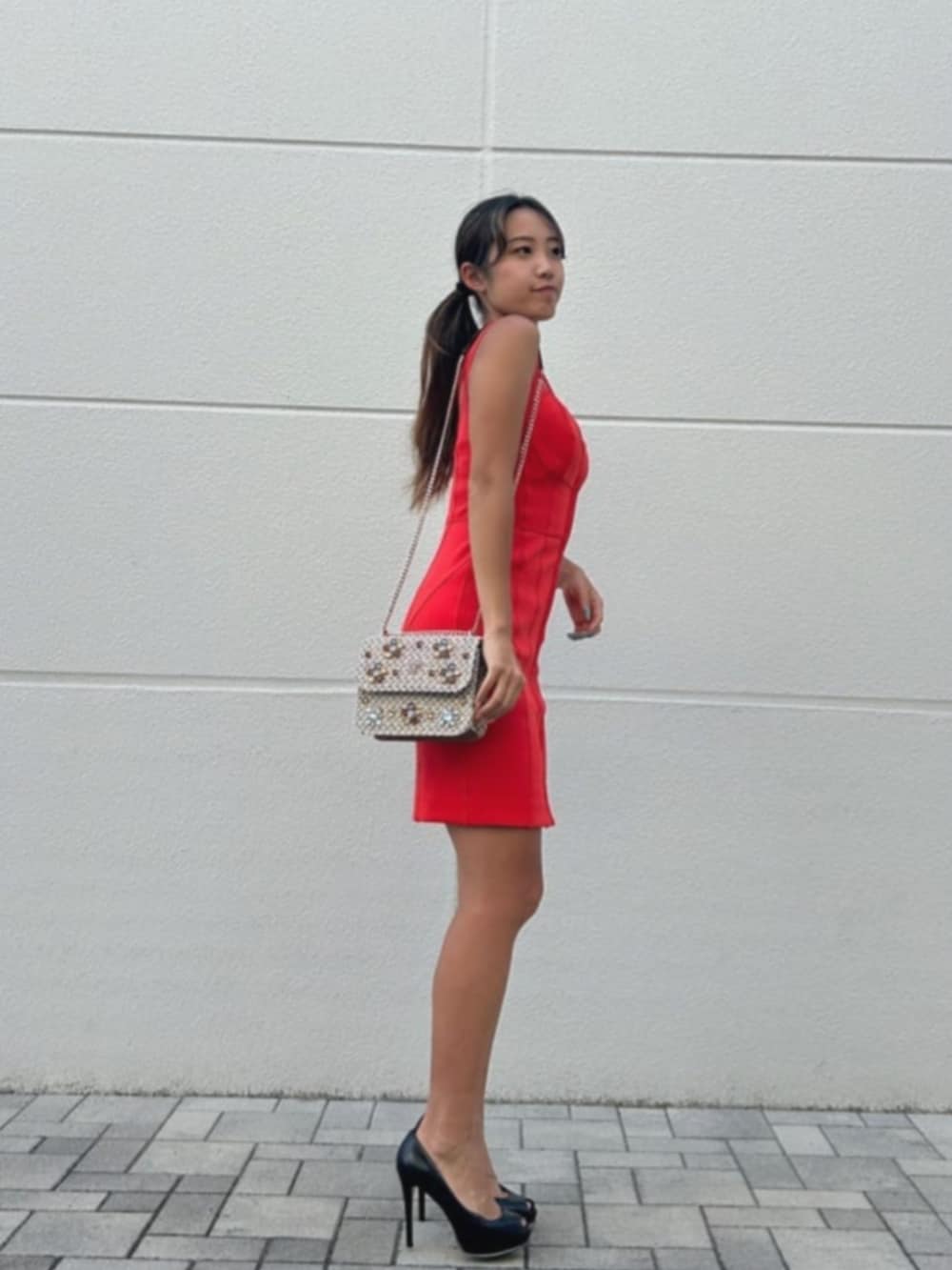 オレンジ系のドレス、ブラウン系のショルダーバッグを着用したレディースの秋コーディネートの3枚目の写真