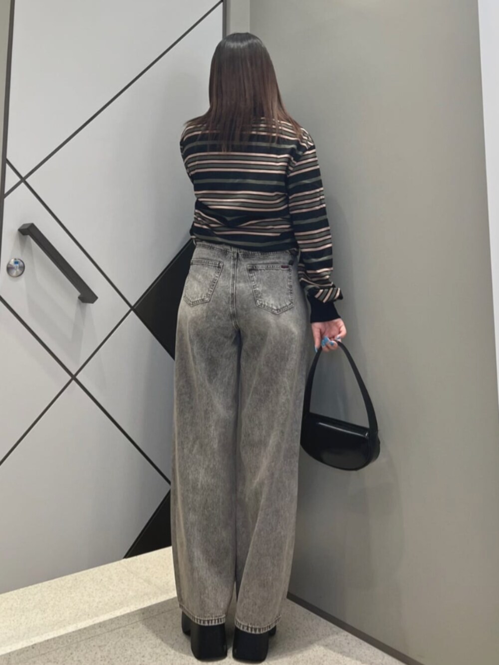 ブラック系のショルダーバッグ、ブラック系のTシャツ/カットソー、グレー系のデニムパンツを着用したレディースの夏コーディネートの2枚目の写真