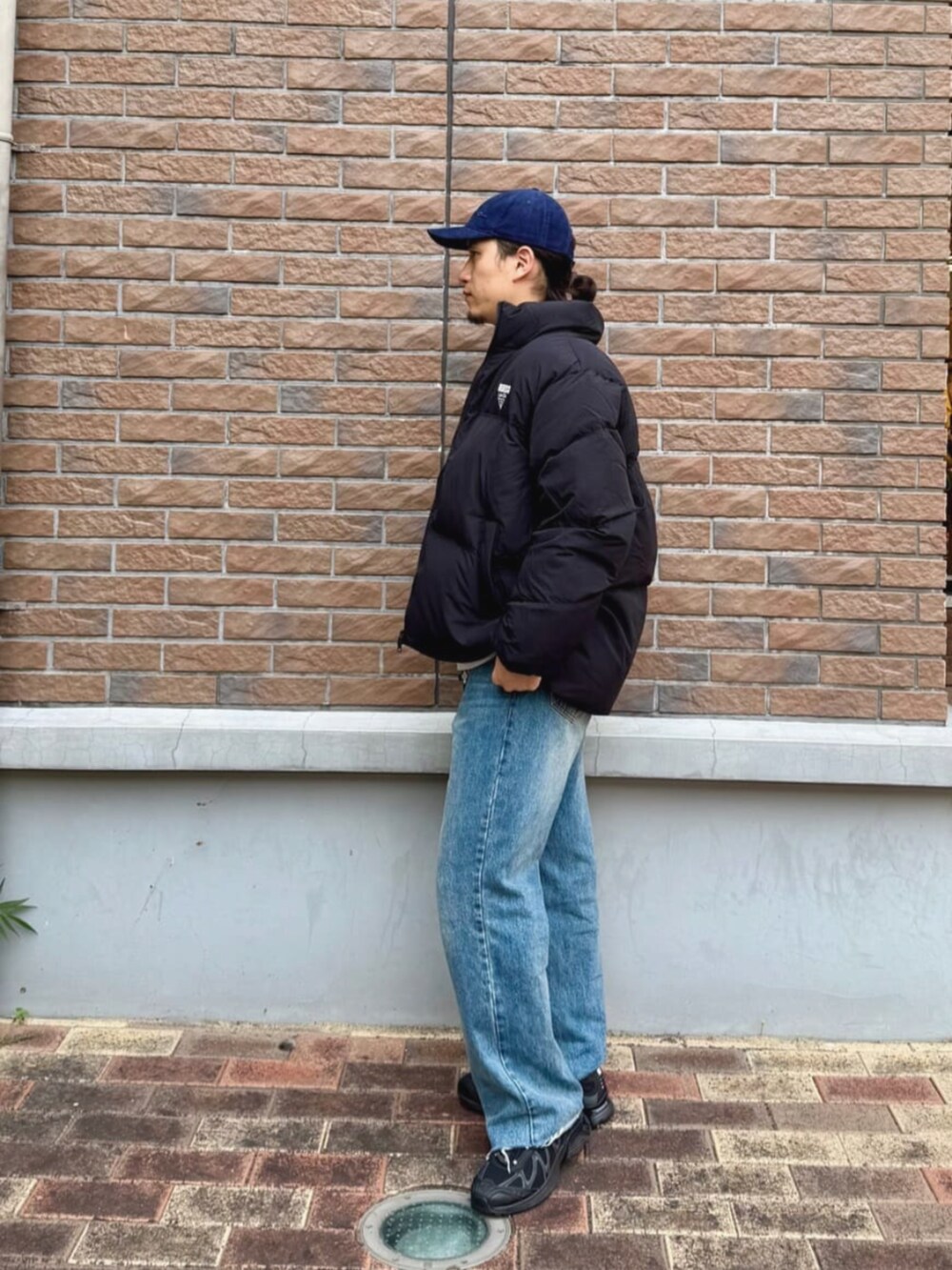 ブラック系のダウンジャケット/コート、ブルー系のキャップを着用したメンズの秋コーディネートの3枚目の写真