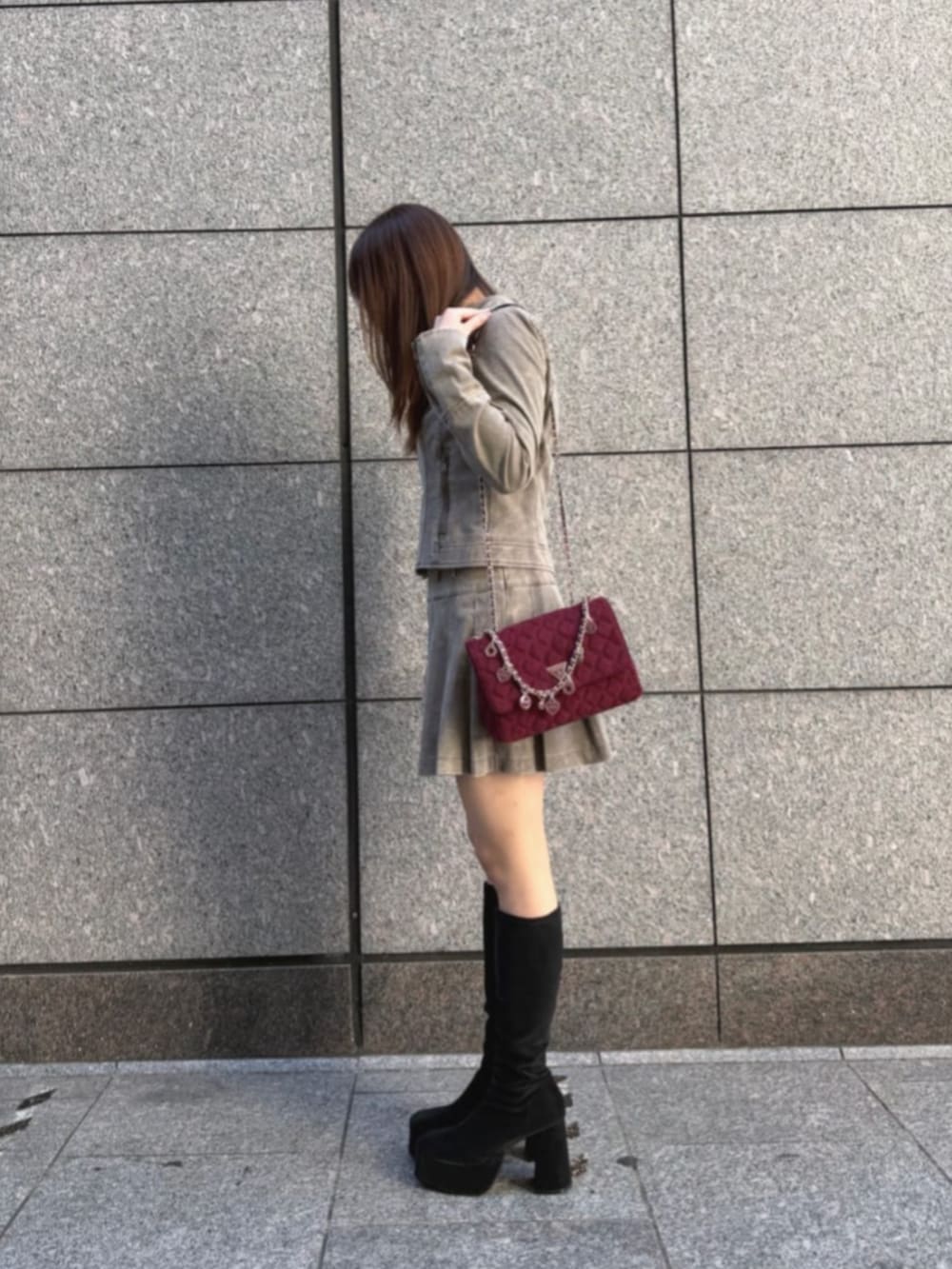 ベージュ系のノーカラージャケット、レッド系のショルダーバッグ、ベージュ系のスカートを着用したレディースの冬コーディネートの3枚目の写真