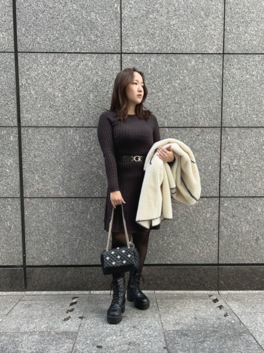 ブラウン系のワンピース、ブラック系のショルダーバッグ、ホワイト系のノーカラージャケットを着用したレディースの秋コーディネートの4枚目の写真