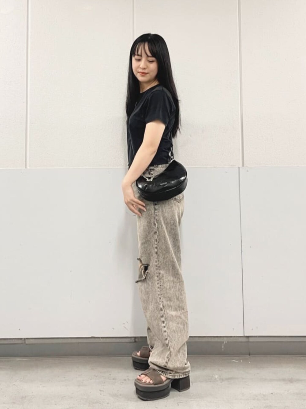 グレー系のデニムパンツ、ブラック系のTシャツ/カットソー、ブラック系のハンドバッグを着用したレディースの夏コーディネートの3枚目の写真