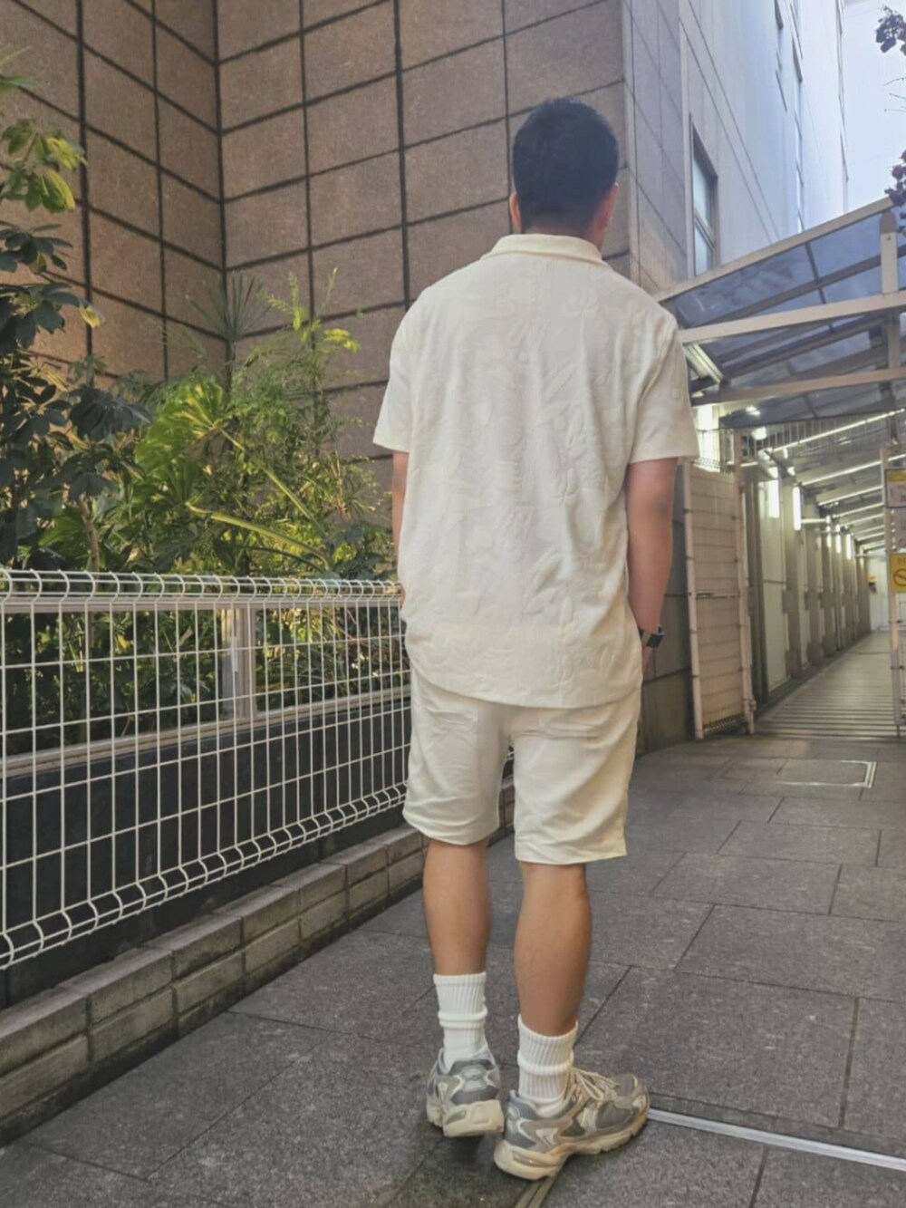 ホワイト系のポロシャツ、ホワイト系のその他パンツを着用したメンズの夏コーディネートの2枚目の写真