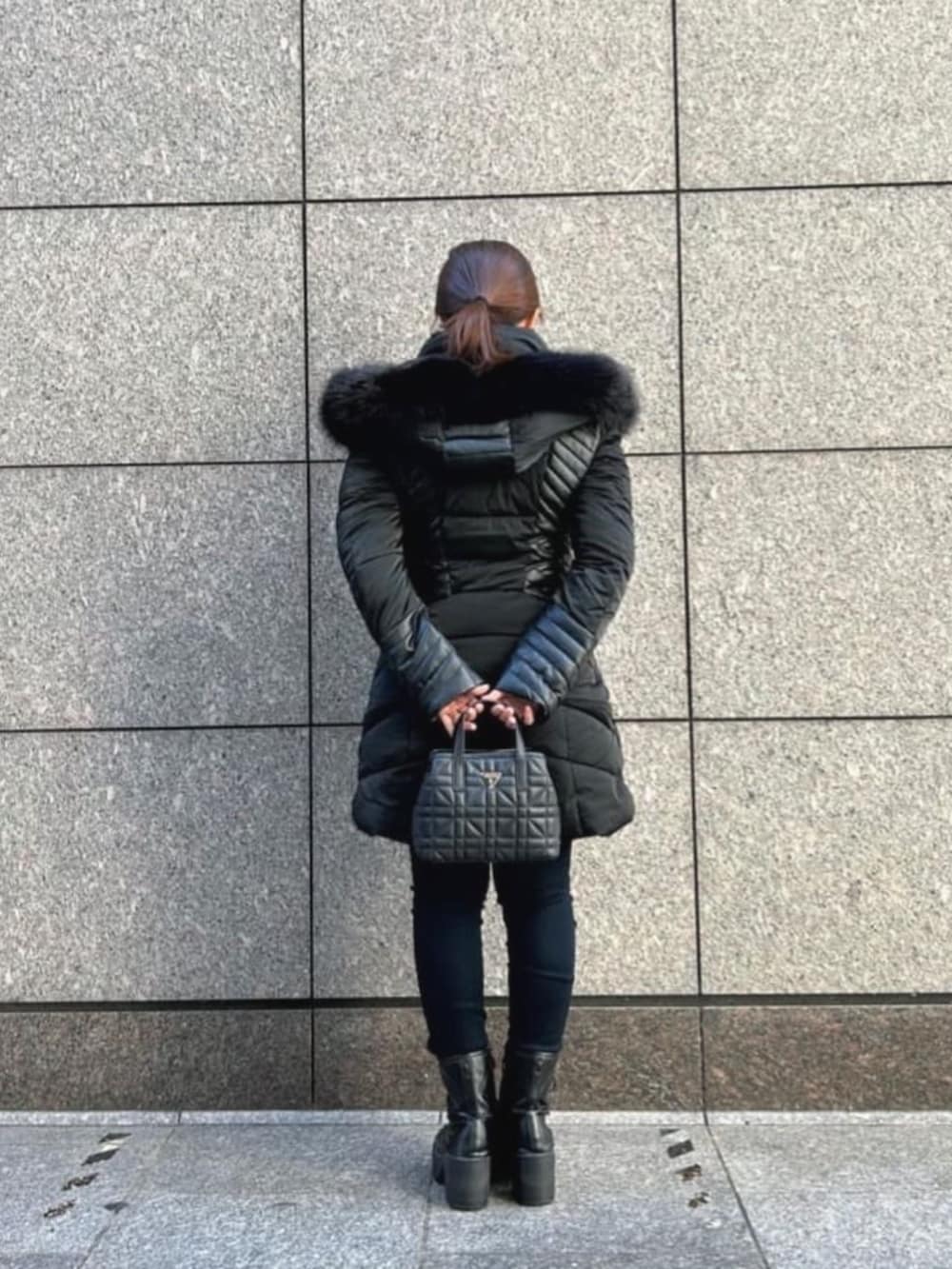 ブルー系のデニムパンツ、ブラック系のショルダーバッグ、ベージュ系のカーディガン/ボレロを着用したレディースの秋コーディネートの2枚目の写真