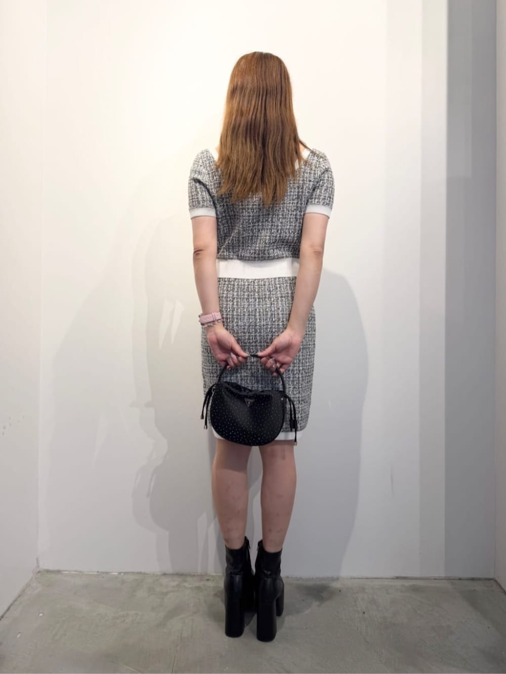 ブラック系のハンドバッグ、ブラック系のワンピースを着用したレディースの春コーディネートの2枚目の写真