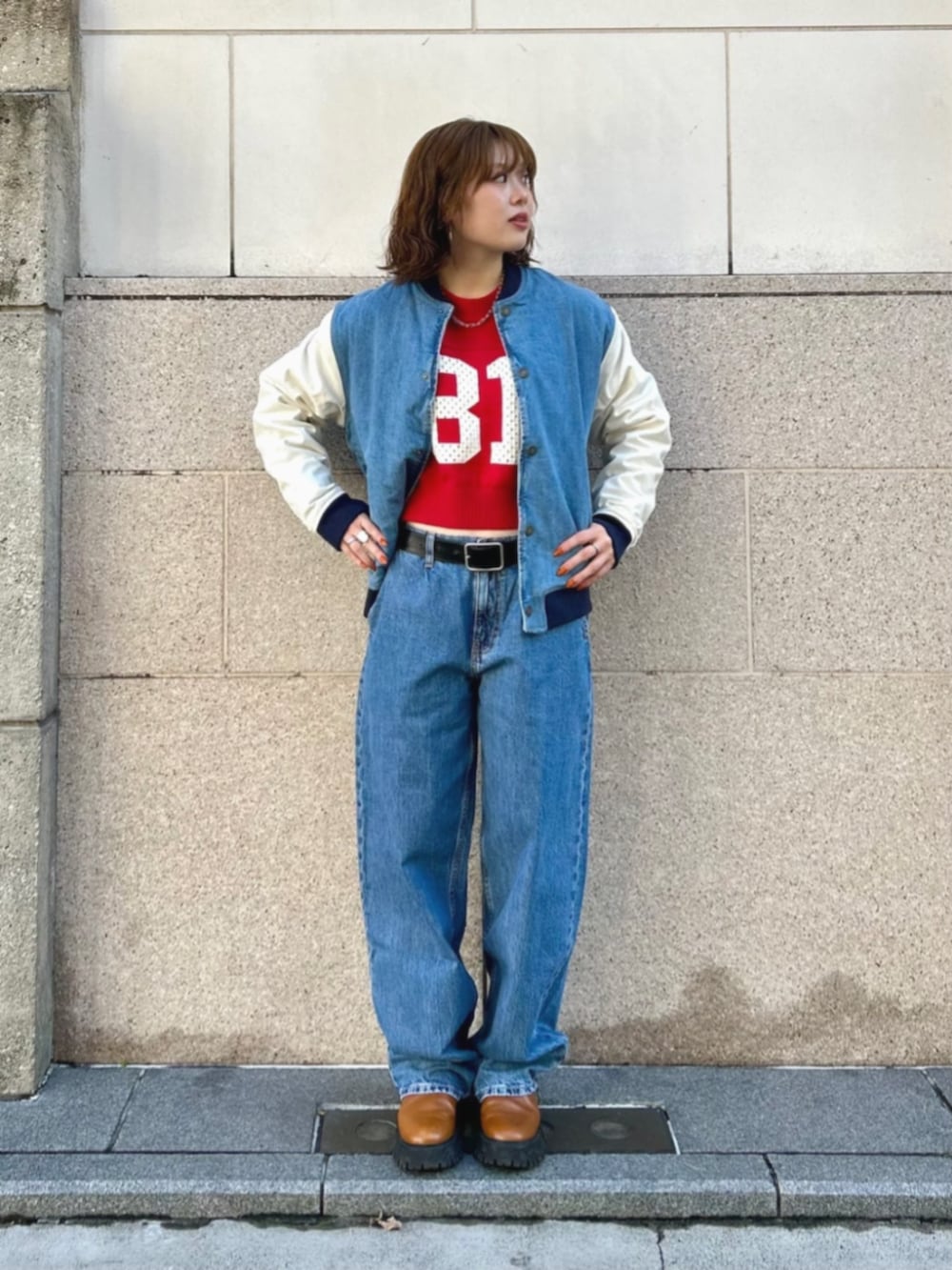 ブルー系のデニムパンツ、ブルー系のスタジャン、ホワイト系のニット/セーターを着用したレディースの冬コーディネートの4枚目の写真