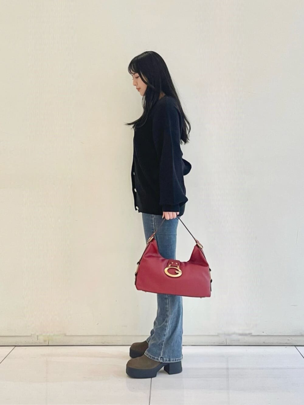 ブルー系のデニムパンツ、ブラック系のタンクトップ、ブラック系のカーディガン/ボレロを着用したレディースの秋コーディネートの3枚目の写真