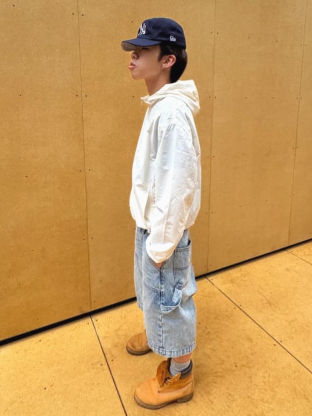 ホワイト系のナイロンジャケット、ブラック系のTシャツ/カットソー、ブルー系のデニムパンツを着用したメンズの夏コーディネートの3枚目の写真