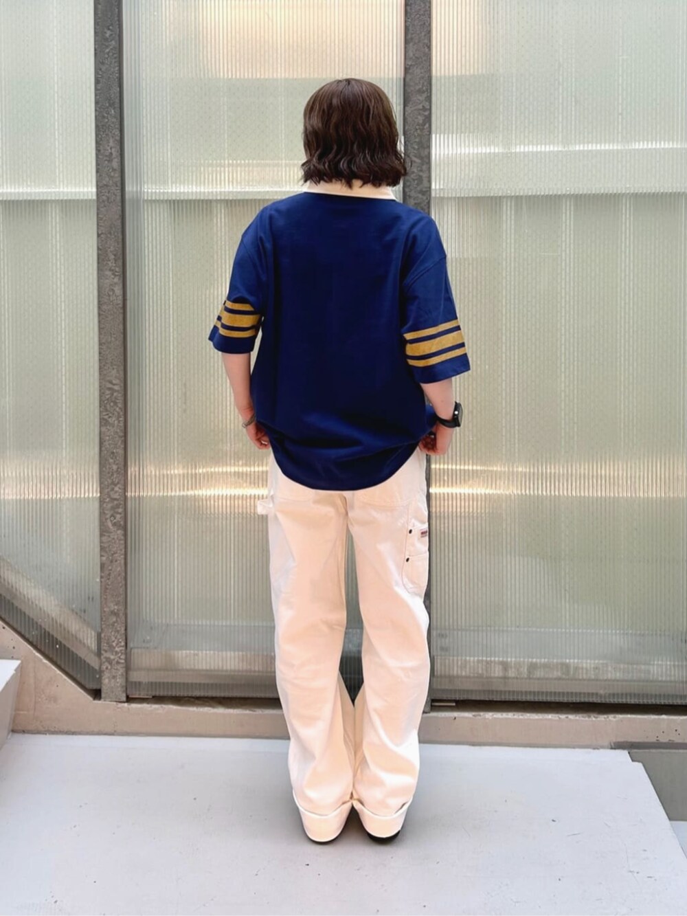 ブルー系のポロシャツ、ホワイト系のカーゴパンツを着用したレディースの秋コーディネートの2枚目の写真