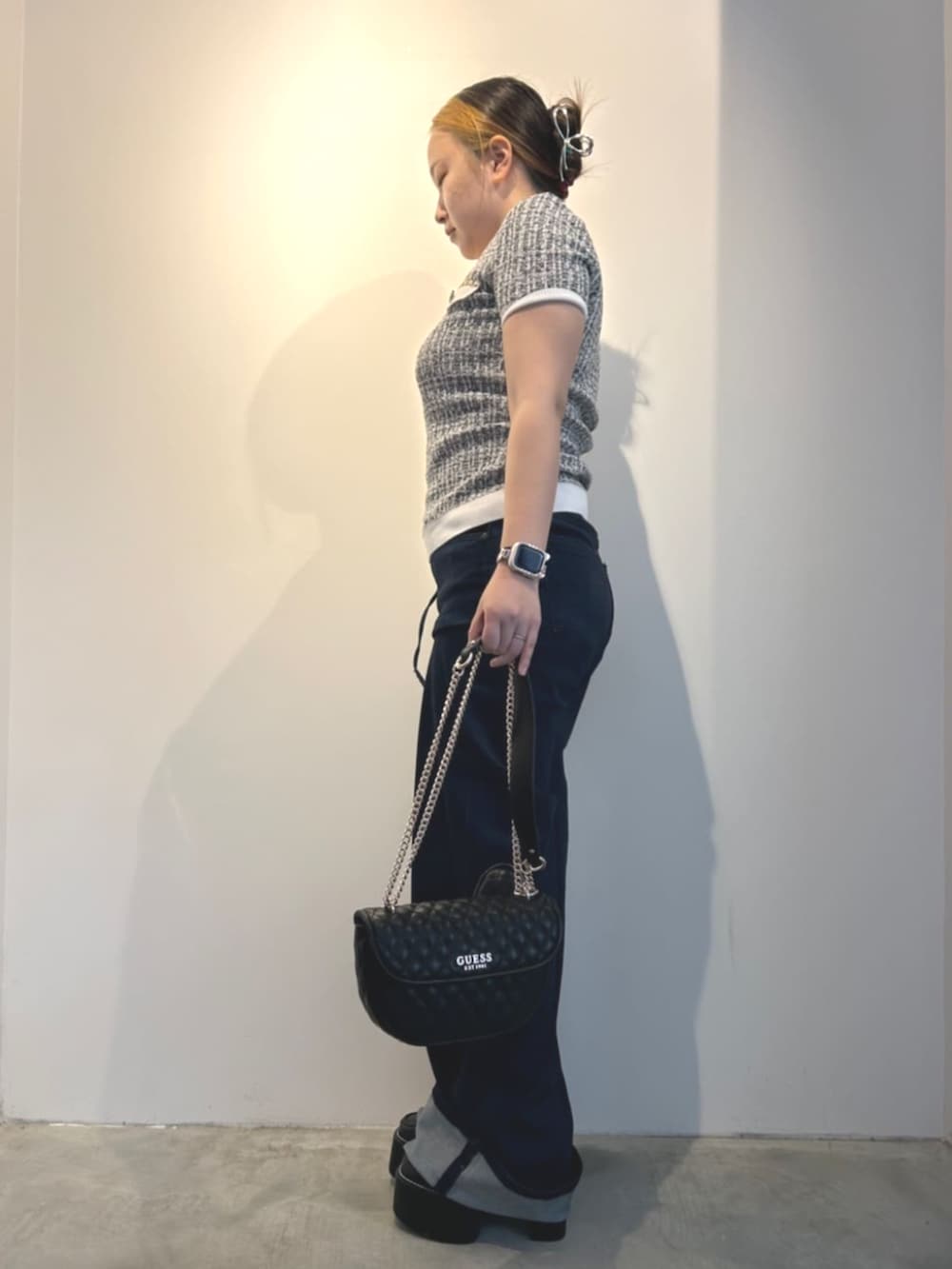 ブラック系のショルダーバッグ、ブラック系のニット/セーター、ブルー系のデニムパンツを着用したレディースの冬コーディネートの3枚目の写真