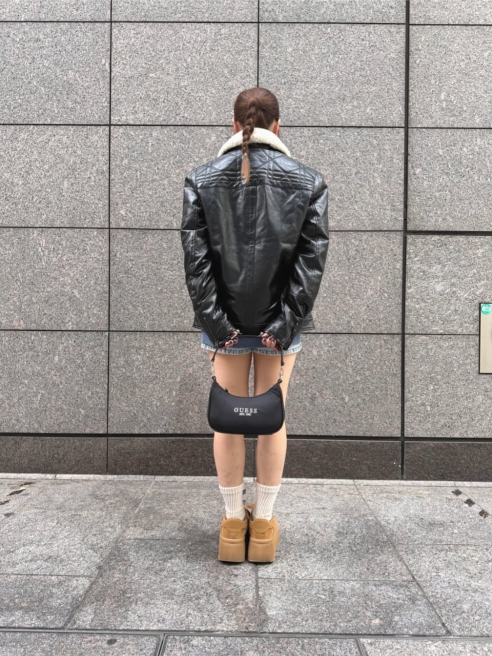 ブルー系のデニムパンツ、ブラック系のショルダーバッグ、ブルー系のスウェットを着用したレディースの冬コーディネートの3枚目の写真