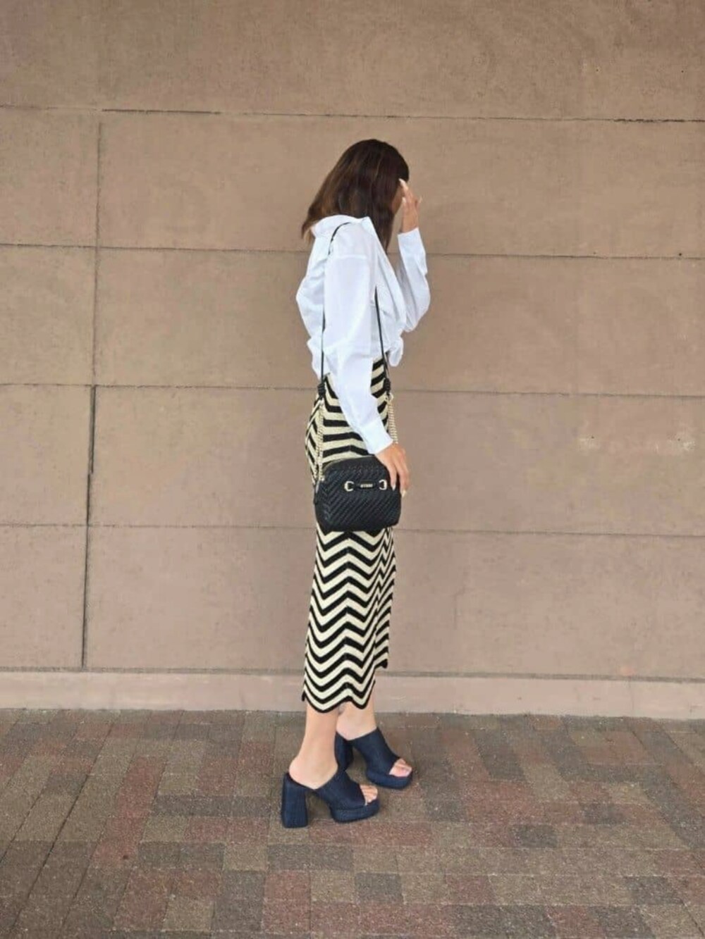 ホワイト系のシャツ/ブラウス、ブラック系のワンピース、ブラック系のショルダーバッグを着用したレディースの秋コーディネートの3枚目の写真