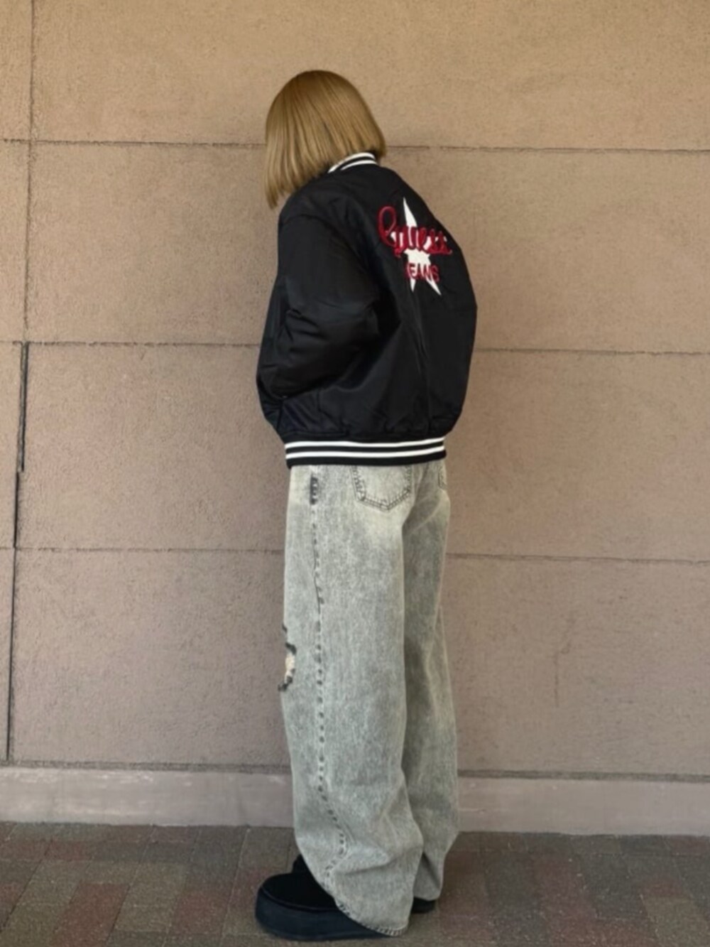 グレー系のデニムパンツ、ブラック系のスタジャン、ブルー系のスウェットを着用したレディースの冬コーディネートの3枚目の写真